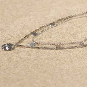 Collier Loustic en métal argenté, maille légère et petit pendentif texturé.