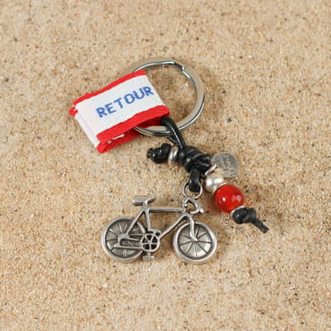 orte clés en métal argenté avec perle en verre rouge et pendentif en forme de vélo.