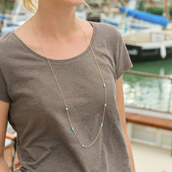 Sautoir chaine fine dorée avec perles transparentes émeraude. Elegant et lumineux. Fabrication en France.