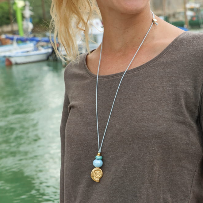 Sautoir fait main en France avec un cordon bleu ciel et un pendentif doré en forme de coquillage