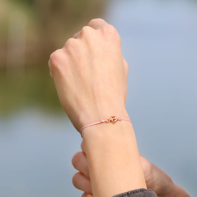 Bracelet artisanal en métal doré avec cordon rose saumon. Création française.