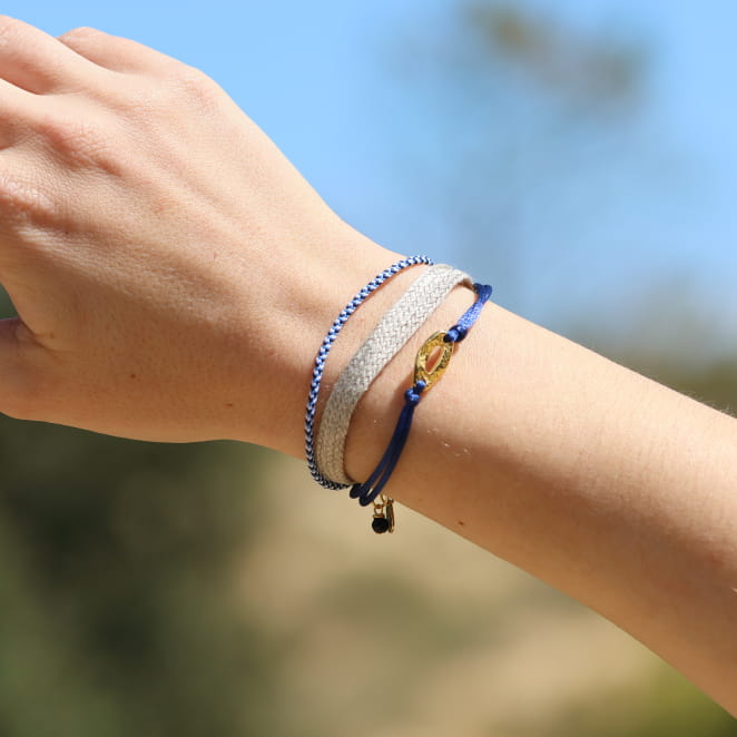 Bracelet artisanal en métal doré avec cordon bleu marine, inspiration bord de mer. Fabriqué en France.