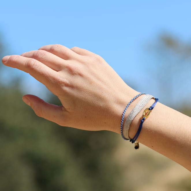 Bracelet en métal doré, cordon bleu marine tressé. Fabrication artisanale française.