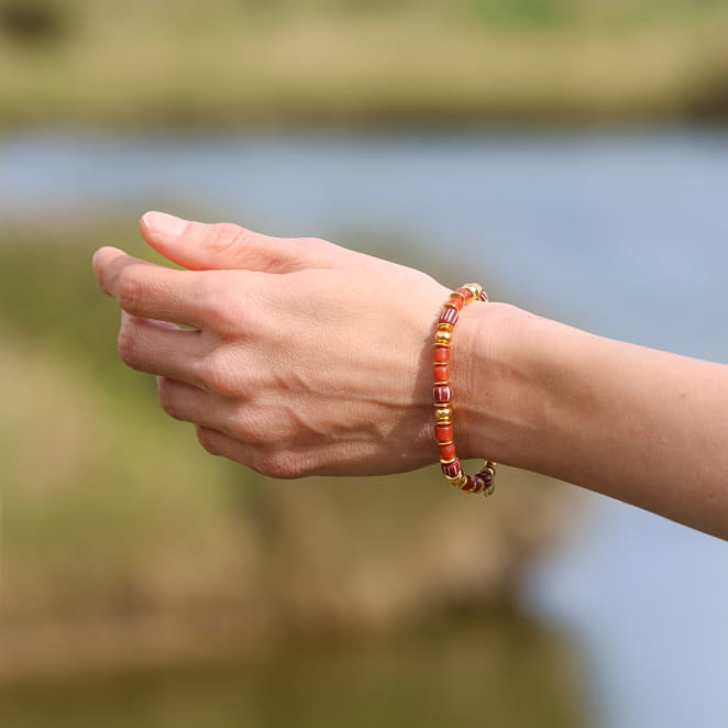 Bracelet en métal doré avec cordon terracotta, création artisanale française.