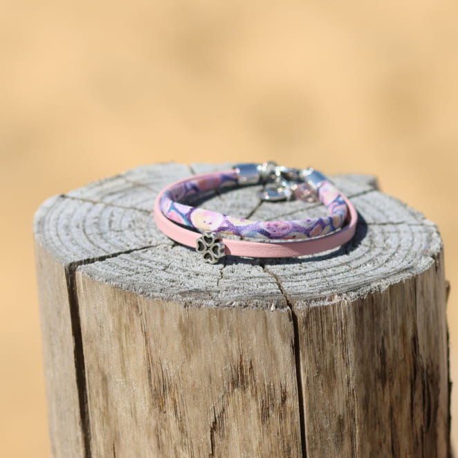Bracelet enfant en métal argenté avec cordon rose pastel. Fabrication artisanale française.
