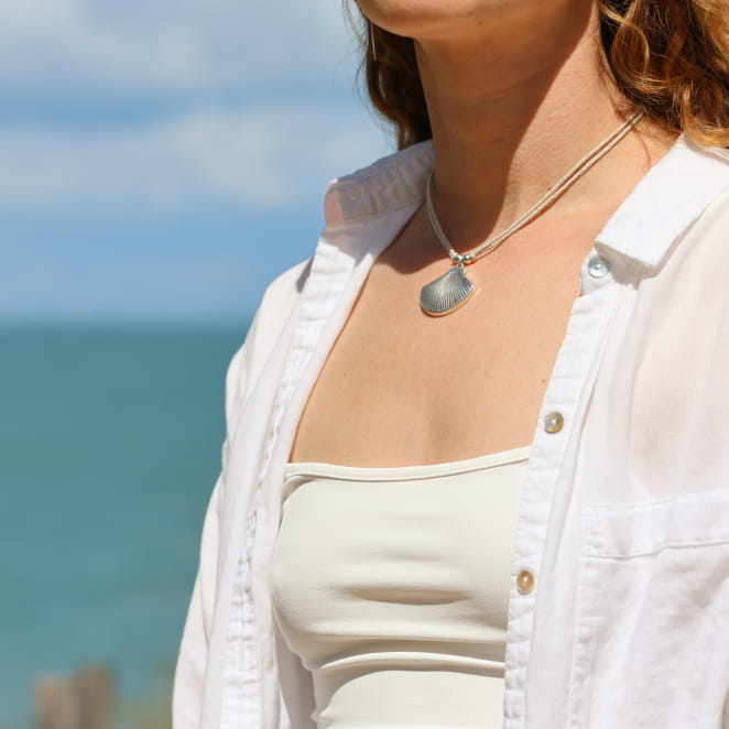 Collier en métal argenté, cordon lin et pendentif travaillé. Fabrication artisanale française.