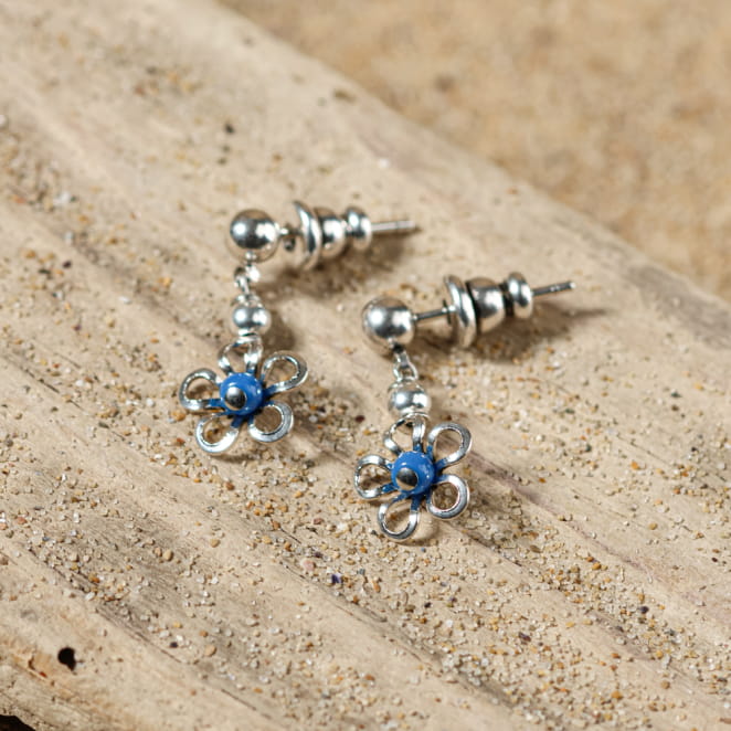 Boucles Flika pour enfant en argent et bleu, posées sur le sable – fabrication française