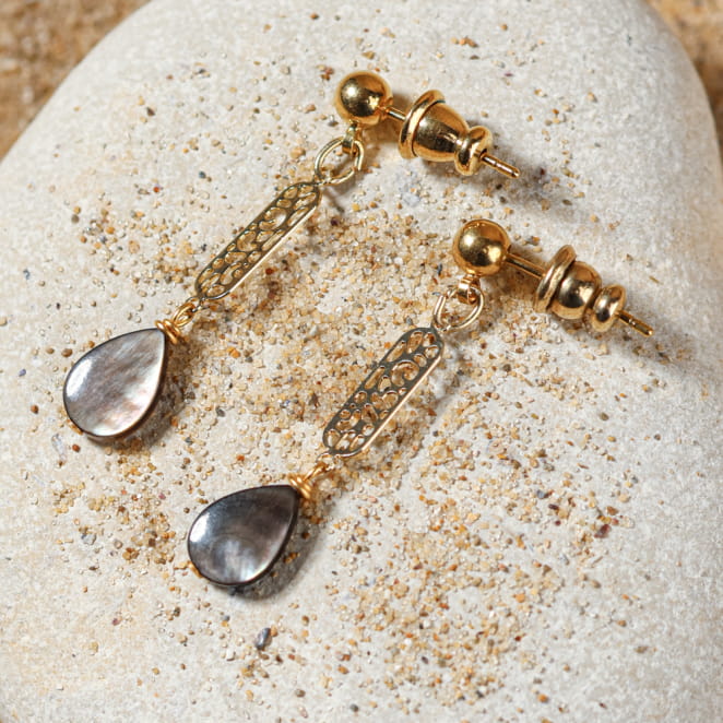 Boucles Turini dorées et grises sur fond sable – bijou fait main en France