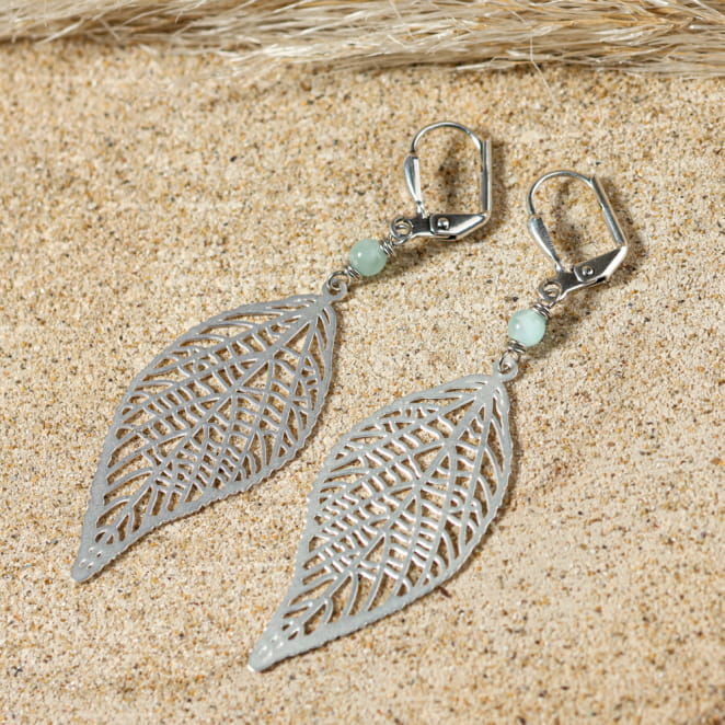 Boucles Alisier argentées et perles vert d’eau posées sur le sable – fabrication artisanale française