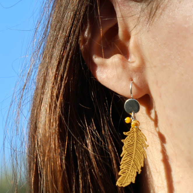 Boucles Ara argentées avec perles jaunes, portées sur fond ensoleillé – bijou fait main