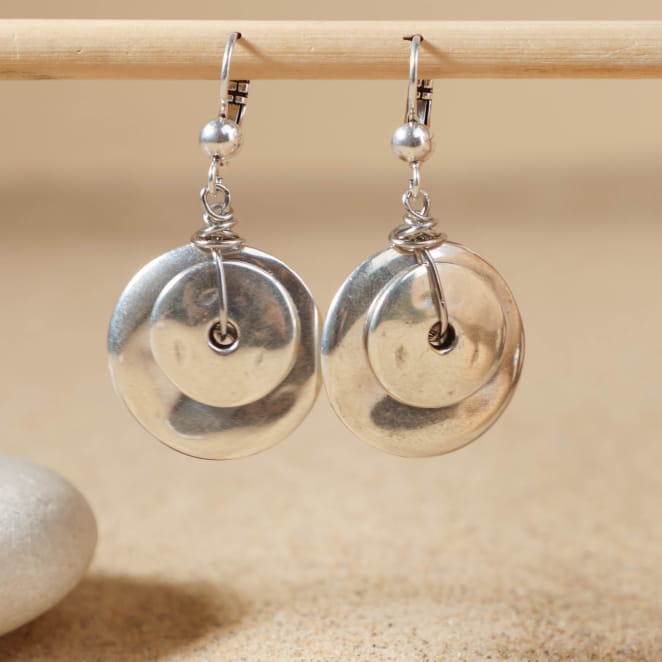 Boucles d’oreilles Sidonie en argent, suspendues sur fond sable – création artisanale française