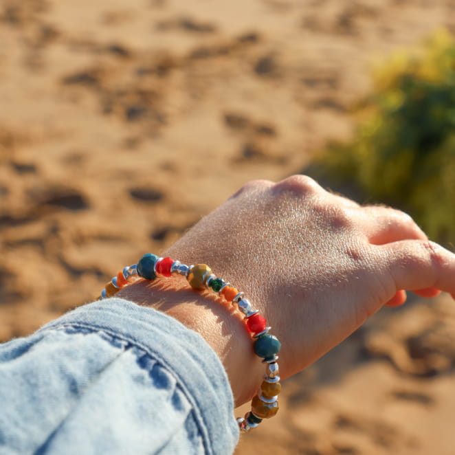 Bracelet Facette multicolore et argenté sur fond sableux – porté de manière estivale – fait main sur l’Île d’Oléron