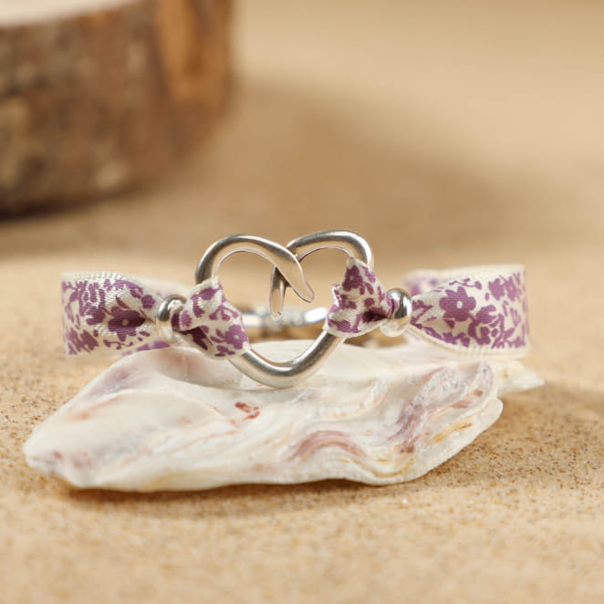 Bracelet violet en perles fimo et argenté, bijou artisanal posé sur un fond naturel