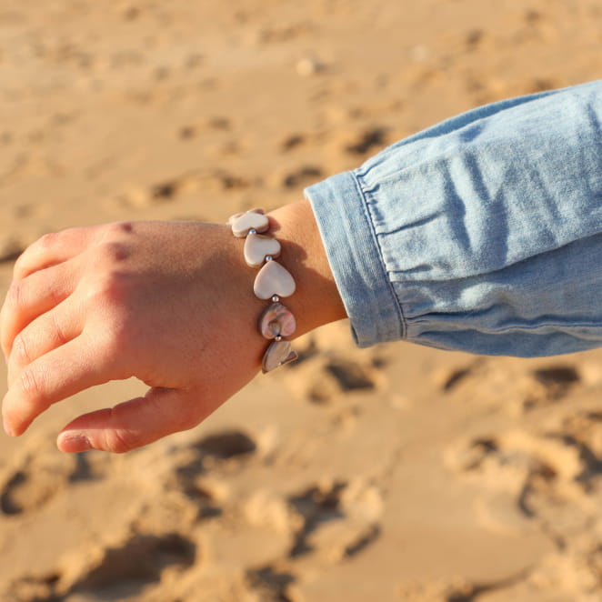 Gros plan sur le bracelet Love argenté et gris porté avec une chemise en jean – création française