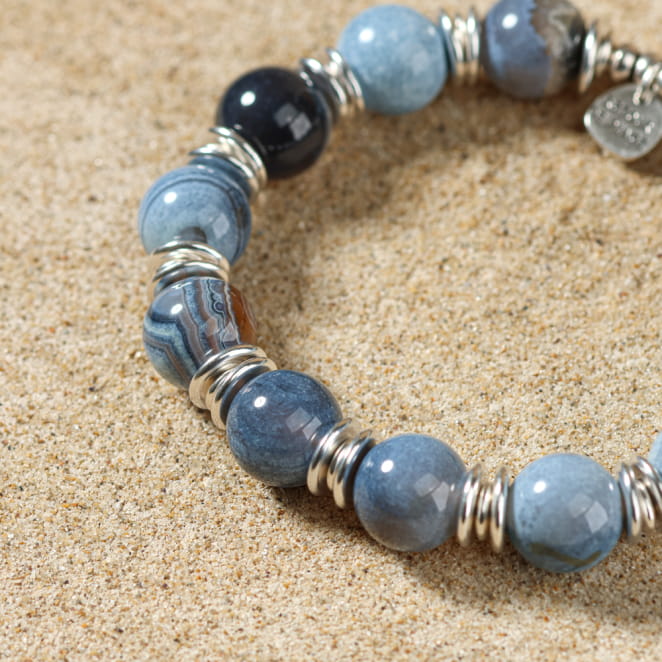 Zoom sur le bracelet Minke bleu profond, bijou artisanal posé sur le sable
