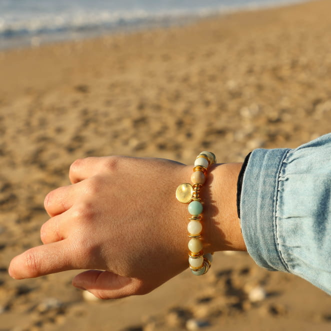 Bracelet Valentina doré et perles vert d’eau porté sur chemise en jean – création artisanale française