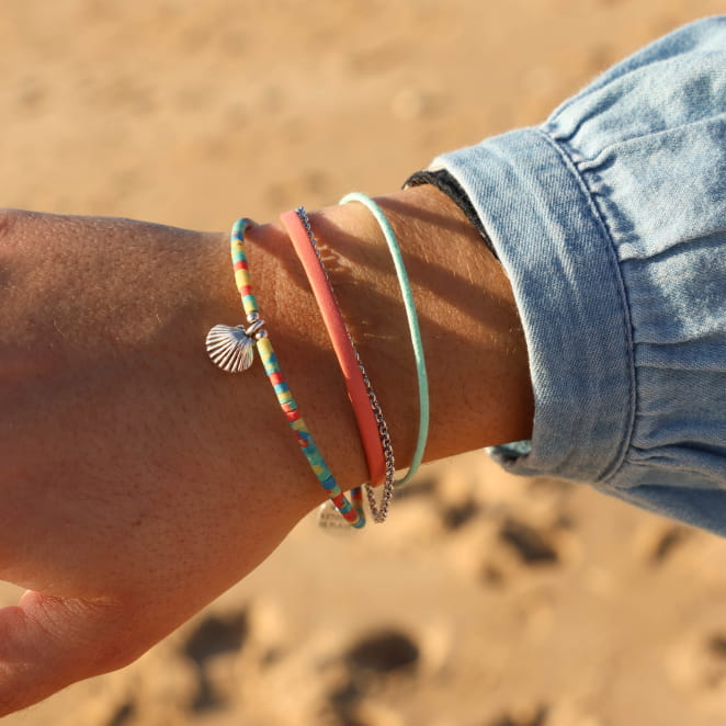 Bracelet Wala multicolore et argenté au poignet – accumulation de bijoux estivaux – fait main en France