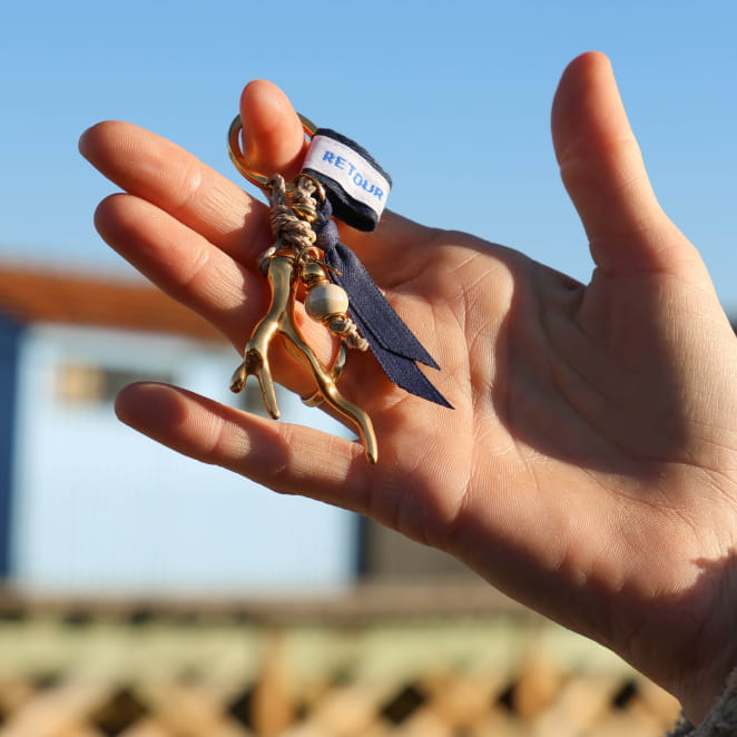 Porte-clés Récif doré avec perles bleu marine et multicolores tenu à la main – création artisanale