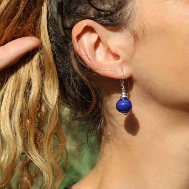 boucle d’oreille Seiche portée, perle bleu intense suspendue à une monture argentée