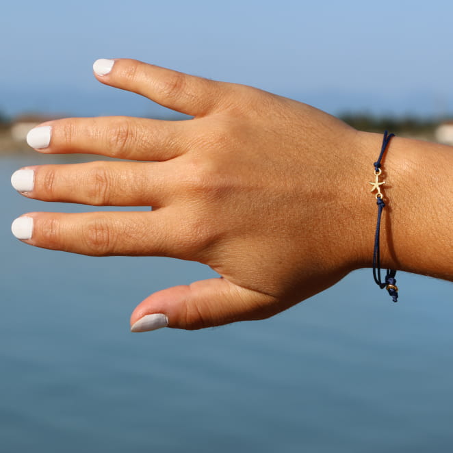 bracelet Transat doré orné d’un cordon bleu marine porté
