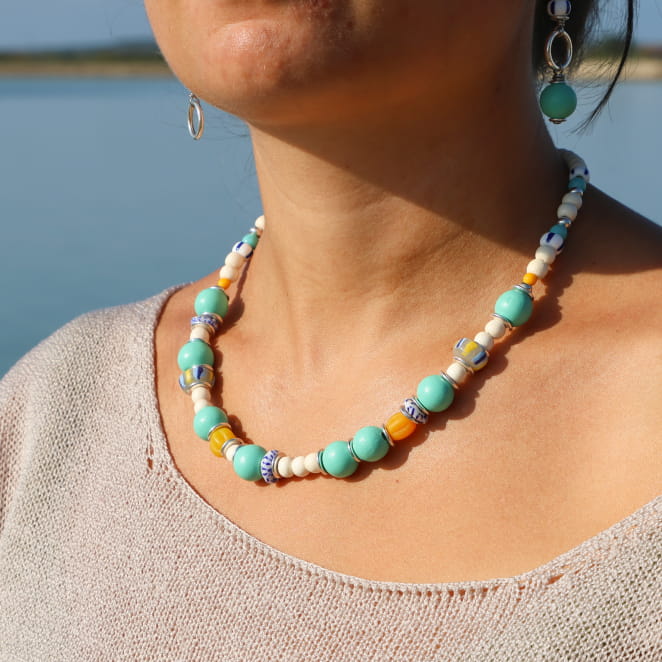 collier Bariolé argenté orné de perles émeraude et multicolores porté