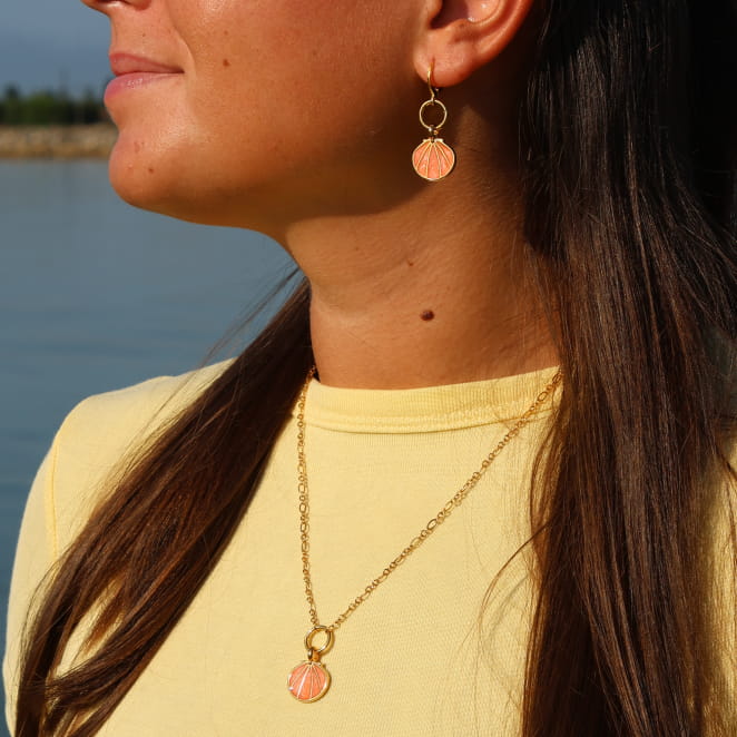 collier Caliopee doré avec pendentif corail porté sur haut jaune