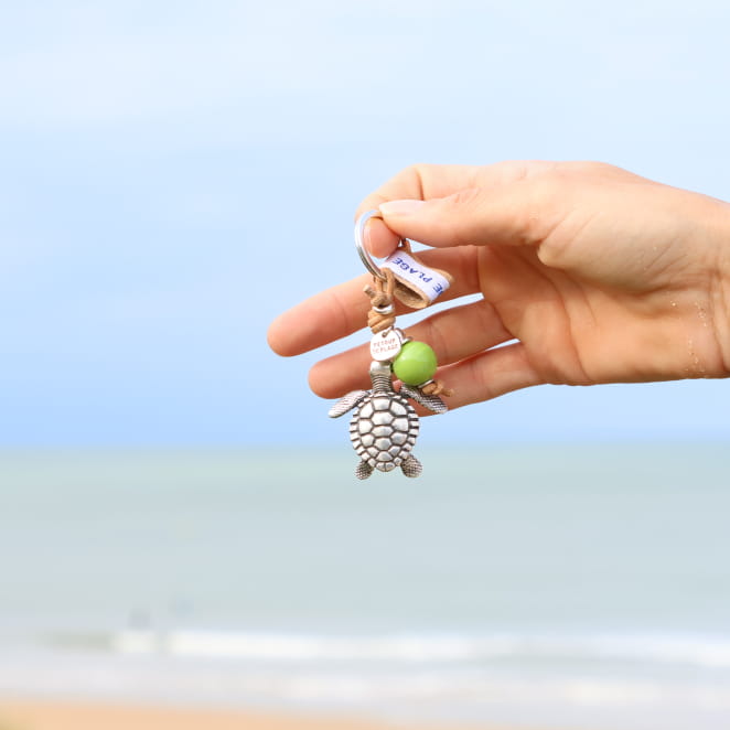 Bijou porte-clés Lente argenté et perle beige, création française raffinée.