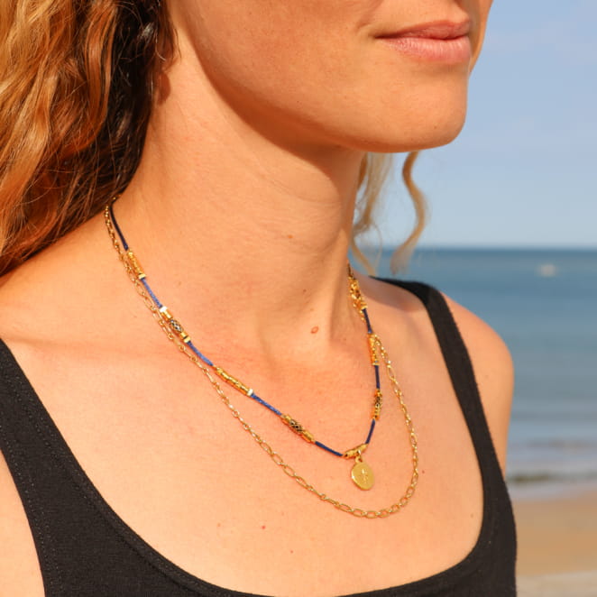 Collier Sourpi doré à l’or fin et perle bleu marine, bijou artisanal français inspiré de l’océan.