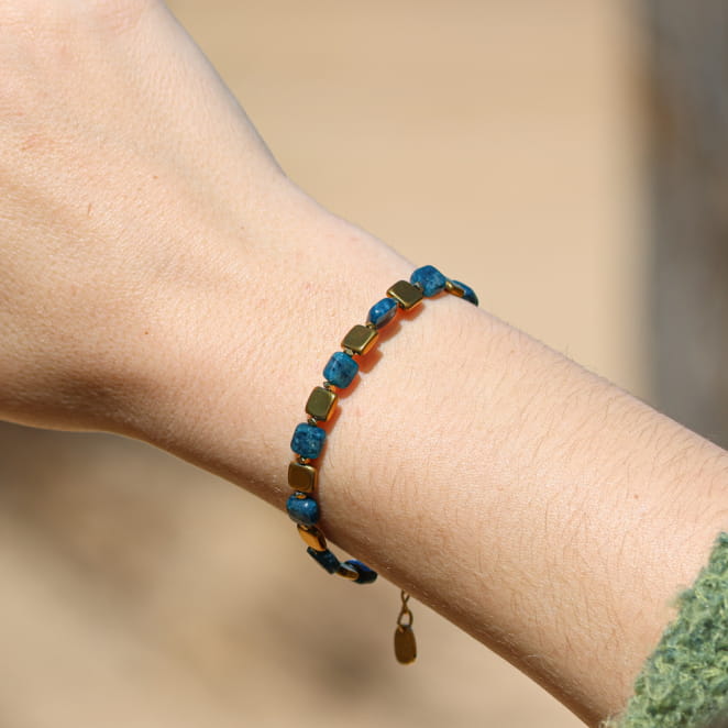 Bracelet en métal doré avec lien bleu pétrole, confection artisanale française.