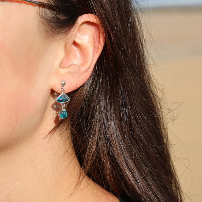 Boucles d'oreilles Joelle Retour de Plage en métal plaqué argent 999, ornées d'une perle facettée en verre bleu et d'un pendentif triangle en verre turquoise transparent – bijou artisanal fabriqué en France