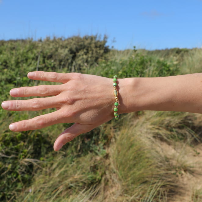 Bracelet artisanal Ceteau vert et doré porté, fabrication française.