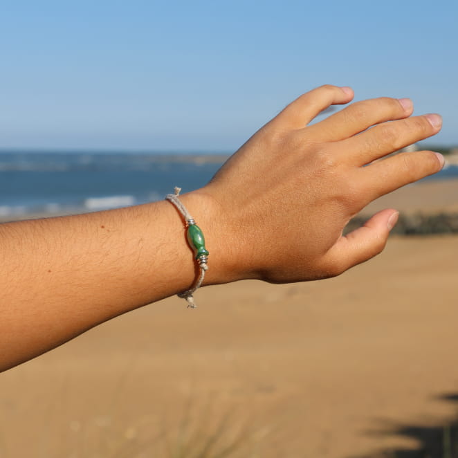 Bracelet Killa porté – bijou en lin naturel avec pendentif poisson en céramique verte et perles en métal argenté, fabrication artisanale française