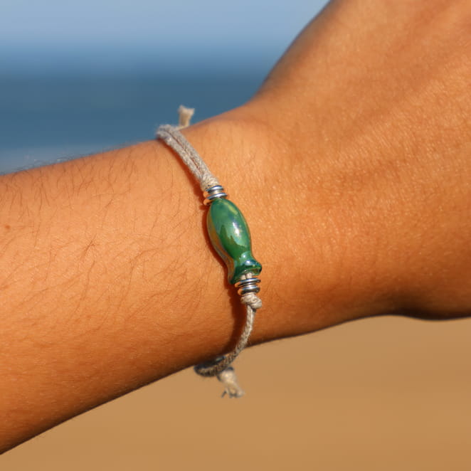 Bracelet Killa Retour de Plage en lin naturel, orné d'un poisson en céramique émaillée verte et de perles rondelles en métal plaqué argent 999 – bijou artisanal fabriqué en France