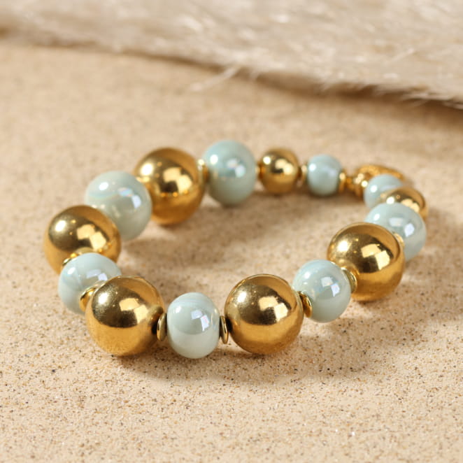 Bracelet Paulette en métal doré orné de perles vert d’eau, création artisanale française.