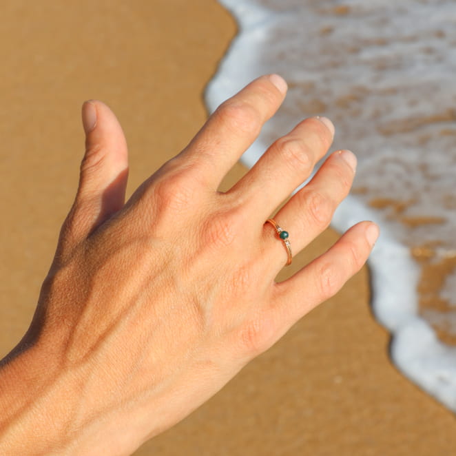 bague Vannetaise dorée avec perle vert bouteille, portée en bord de mer, fabrication française