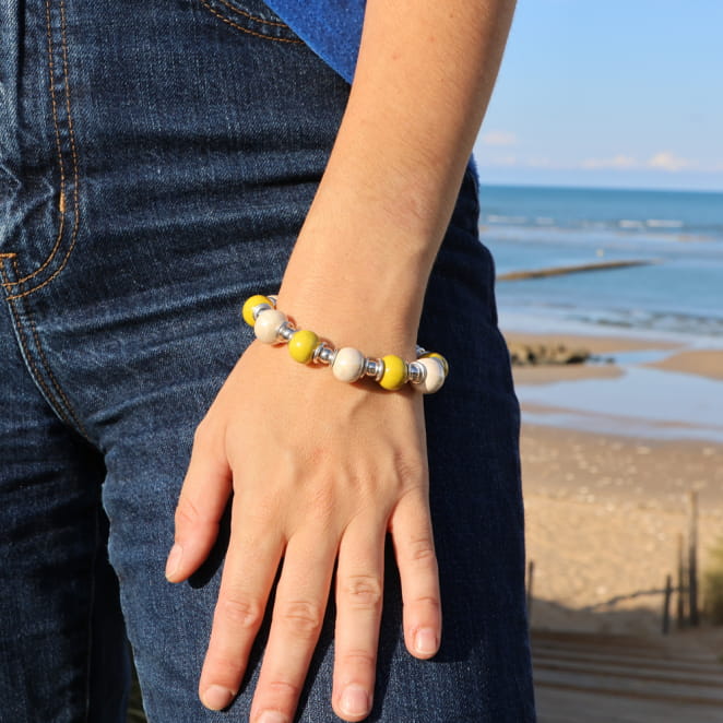 bracelet Ancolie argenté avec perles jaunes et multicolores porté au poignet