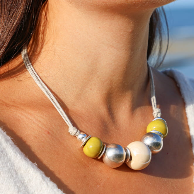 collier Ancolie argenté avec perles jaunes et multicolores porté sur peau bronzée