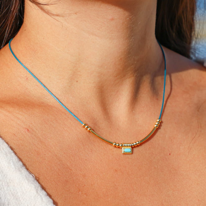 collier Dakota doré avec perle centrale bleu pétrole porté