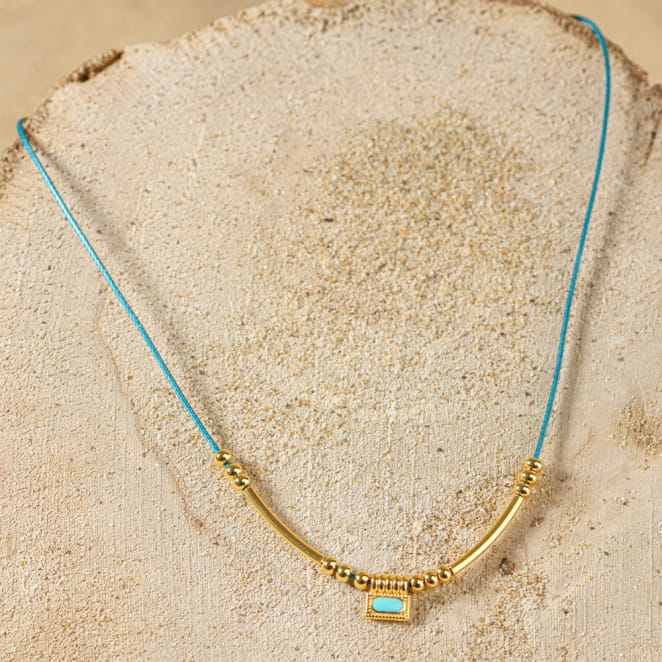 collier Dakota doré avec perle centrale bleu pétrole présenté à plat