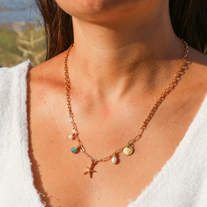 collier Dolcevita doré avec pendentif vert d’eau porté autour du cou