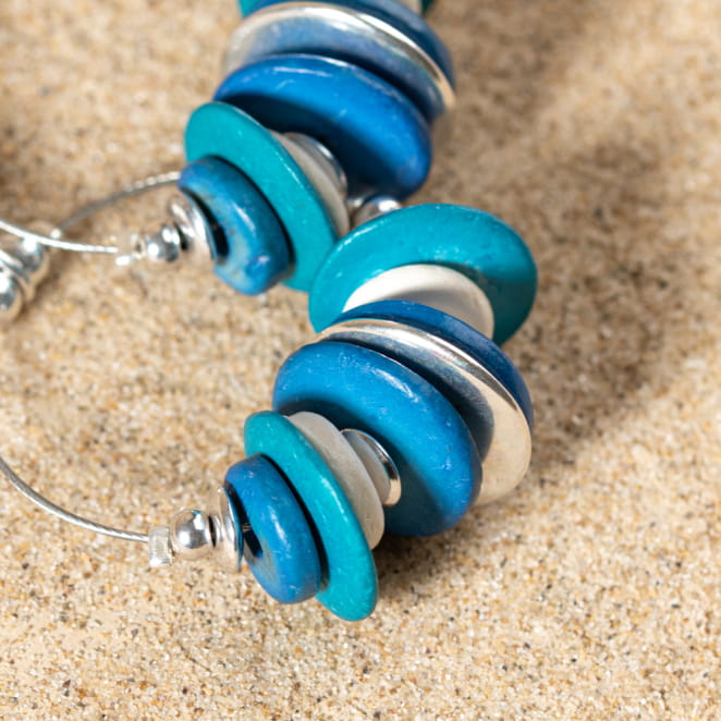 Vue rapprochée des boucles Colada, contrastes de textures et de couleurs pour un style ensoleillé.