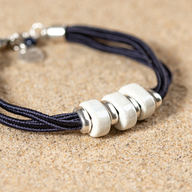 Bracelet Ceram blanc et argenté, perles céramiques montées sur cordon noir, style raffiné.