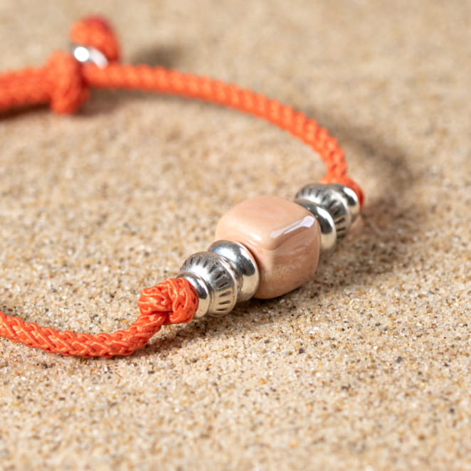 Zoom sur le bracelet saumon, couleurs acidulées et fermoir ajustable argenté.