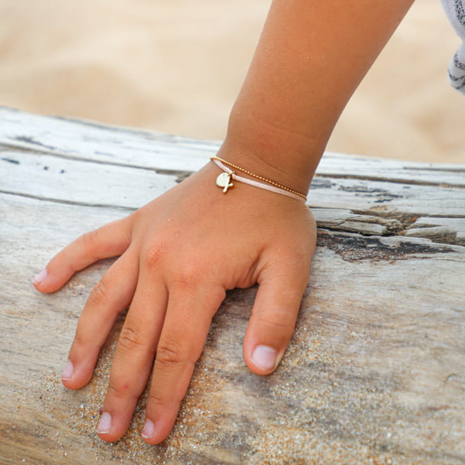 Bracelet enfant Baleine en métal doré et cordon saumon, fabrication artisanale française.