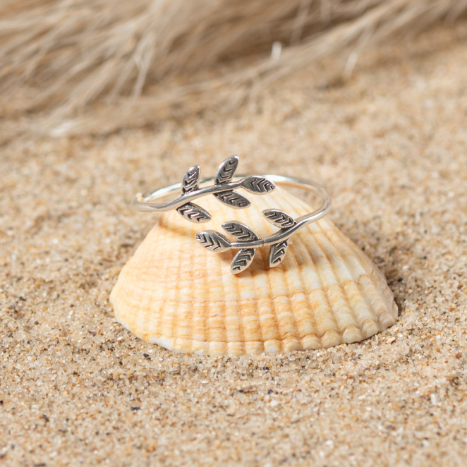 bague Sakura posée sur un coquillage, détail argent et perle centrale
