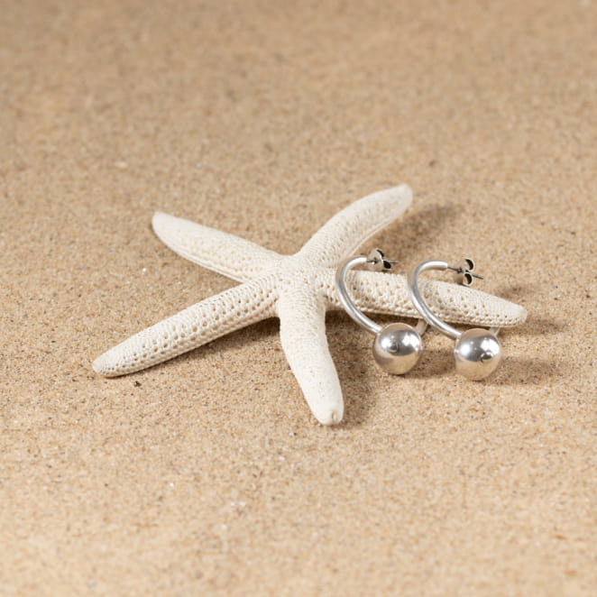 Découvrez Ejade : des boucles d'oreilles coquettes qui se composent de perles en métal argenté et de créoles à clou en métal plaqué argent 999. Fabrication française et artisanale inspiré du bord de mer.