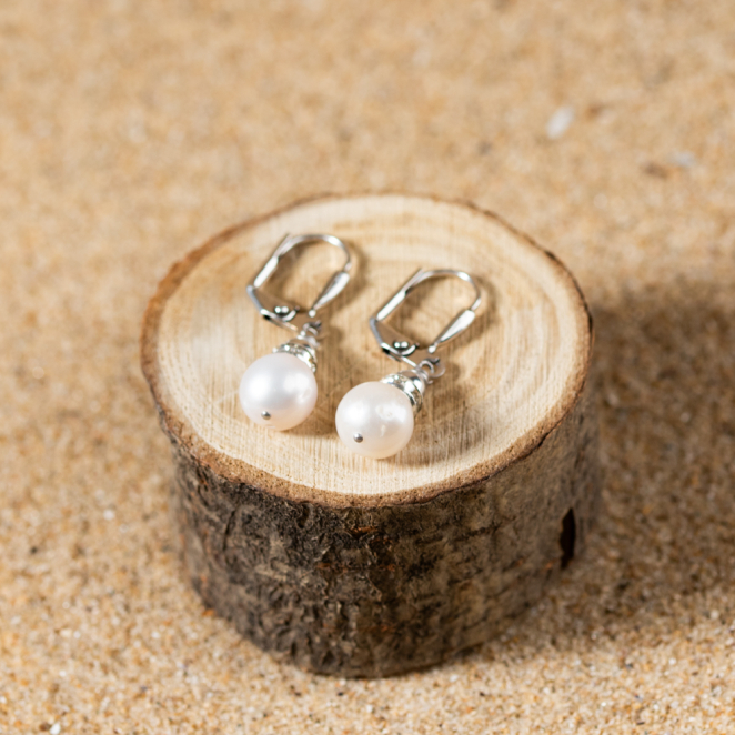 Les boucles d'oreilles Riche incarnent l'alliance parfaite entre la grâce de la nacre et l'éclat de l'argent.