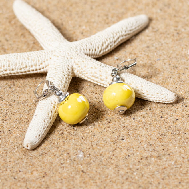 boucles Seiche jaunes posées sur étoile de mer, monture en métal argenté