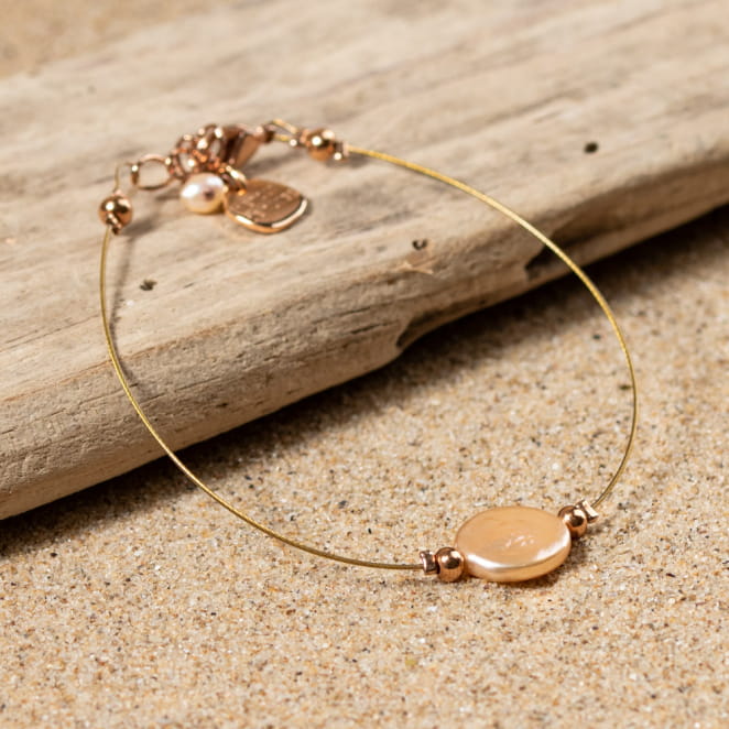 bracelet Flamand posé sur le sable, tons rose doré et perles élégantes