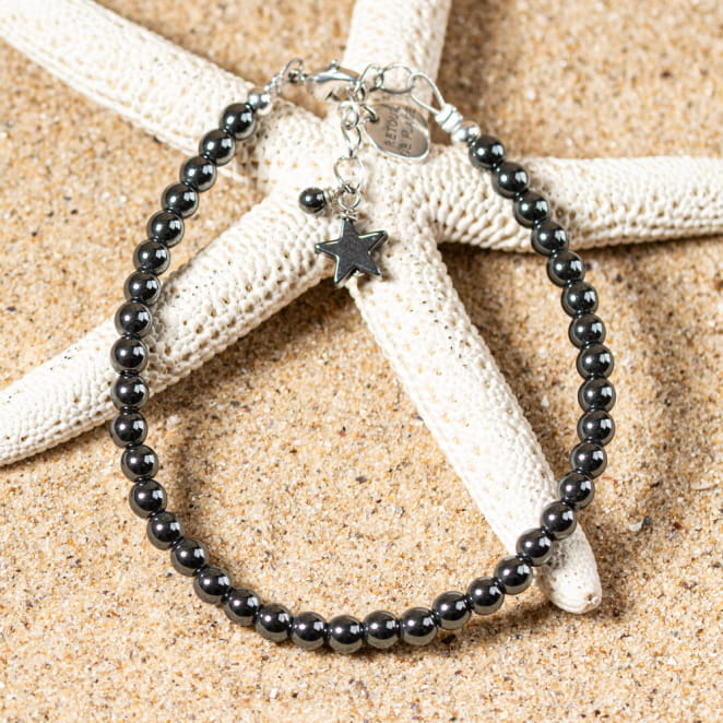 bracelet Goudron gris en perles nacrées sur fond sable, finition artisanale